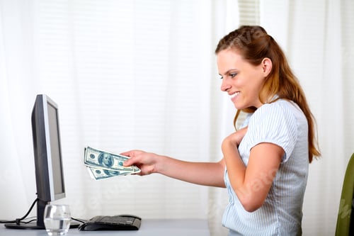 Preview: Portrait Of A Surprised Beautiful Blonde Girl Holding Plenty Of Cash Money While Looking To It In