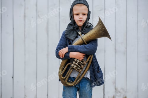 Preview: Funny Guy In Blue Sweater And Vintage Helmet Of Pilot Playing Large Copper Pipe