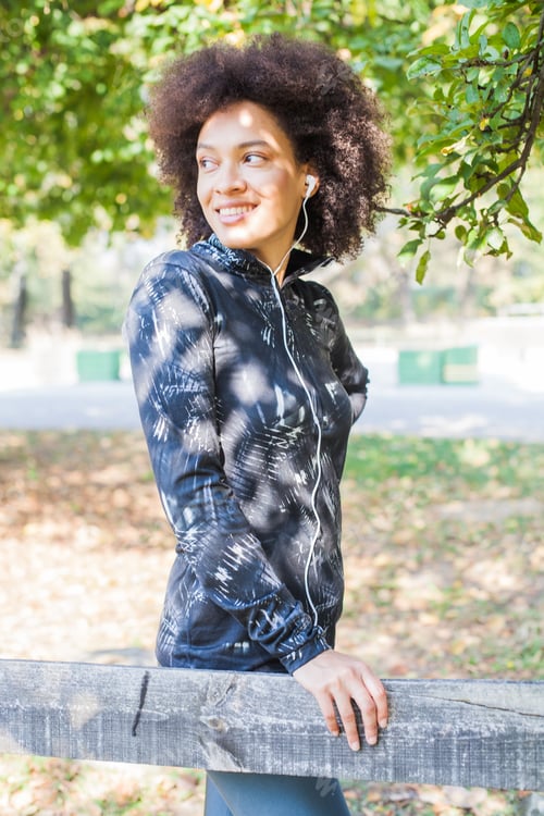 Preview: Attractive Sporty Woman Relax After Training Listening Music At Park, Leaning On Wooden Fence In