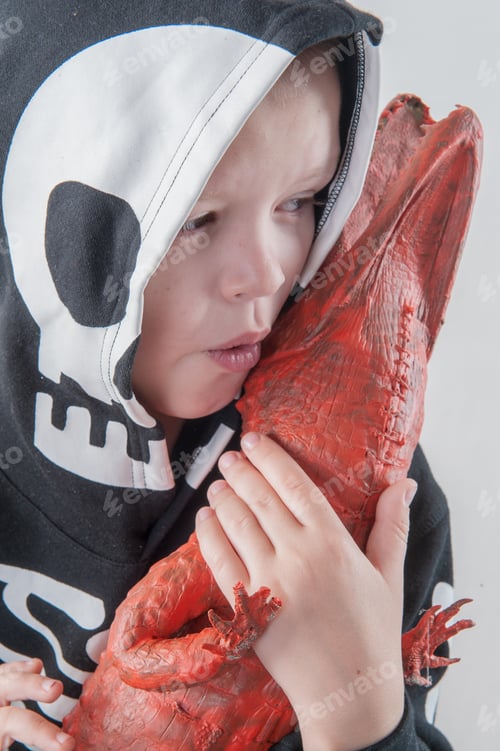 Preview: Happy Child In Carnival Outfits, Boy With Red Crocodile In Studio. Black Suit With The Image Of