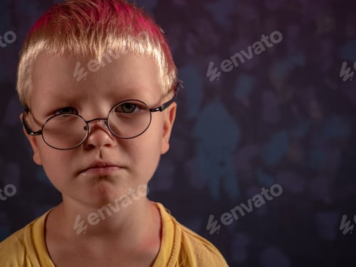 Preview: Cute Blond Child In Yellow T-Shirt And Glasses Posing In Front Of Camera And Smiling