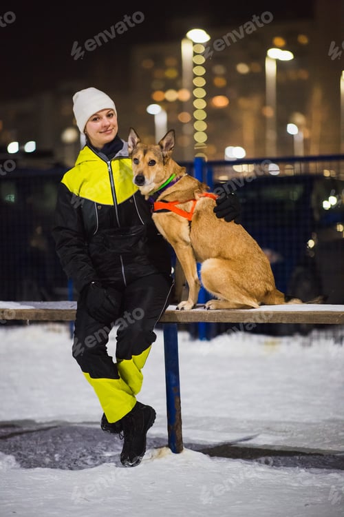 Preview: Portrait Of Young Happy Women Hugging A Red Hair Mixed Breed Dog At Playground.