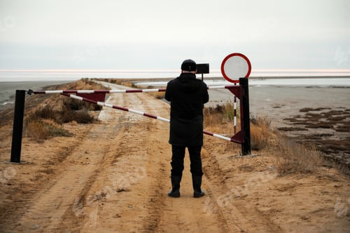 Preview: Man Stands On Road In Front Of Closed Gate And Restrictive Traffic Signs. Salt Lake Elton