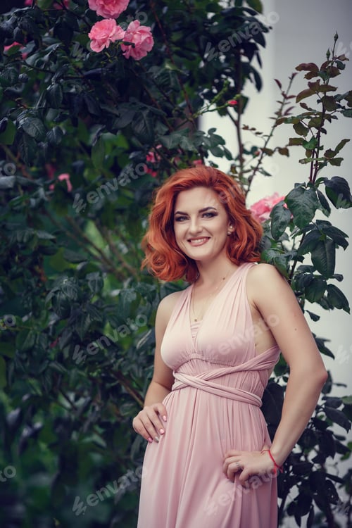Preview: Lovely Young Woman In A Pink Dress And Red Hair, Waiting For A Date. A Walk Through The Summer