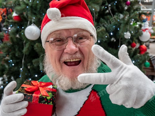 Preview: Elderly Man With Gray Beard And Mustache Wearing Santa Claus Hat And Carnival Clothes In Festive