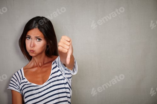 Preview: Unsatisfied Young Lady Showing Disapproval Sign While Looking At Camera - Copy Space