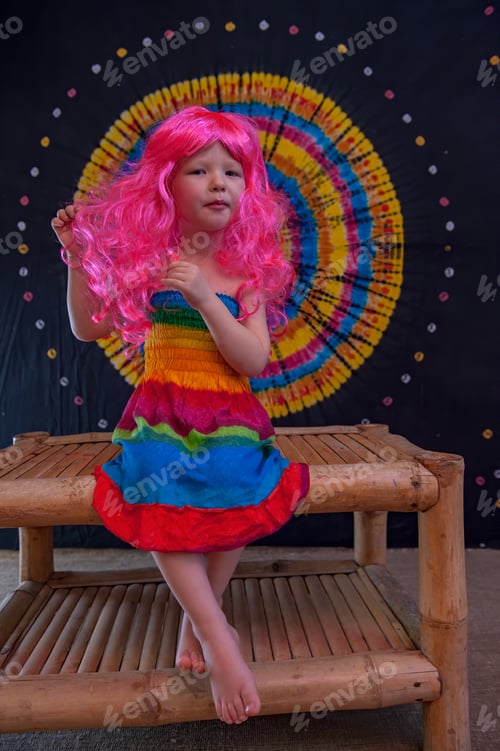 Preview: Happy Cute Caucasian Boy Changed Clothes At Carnival In Dress Of Girl Of Rainbow Color. Pink Doll