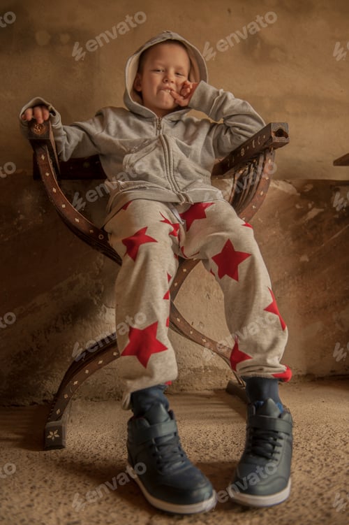 Preview: Caucasian Kid Playing On Vintage Chair. Kid Sits On Office Chair And Shows Feet. Sharpness On Shoes