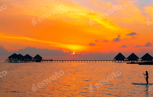 Preview: A Picturesque Sunset In The Maldives And The Silhouette Of A Girl Floating On A Paddle Board