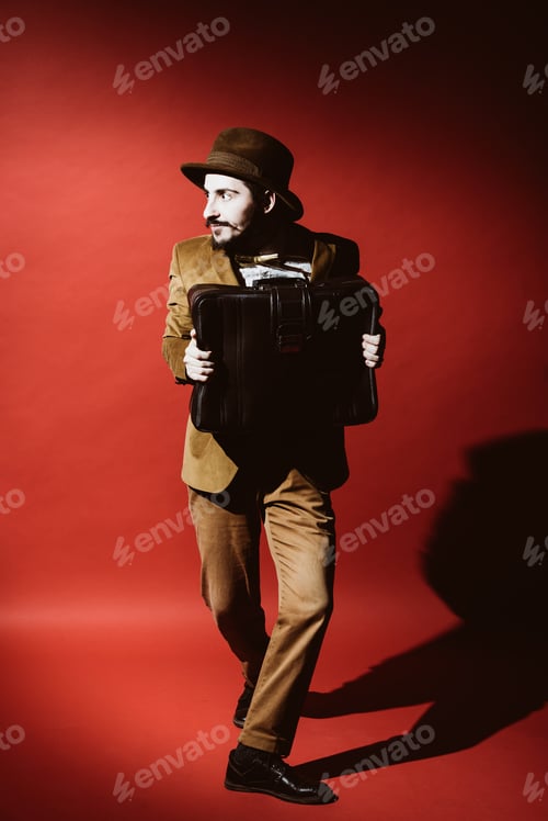 Preview: Man In Suit Posing In Studio With Suitcase In Hands