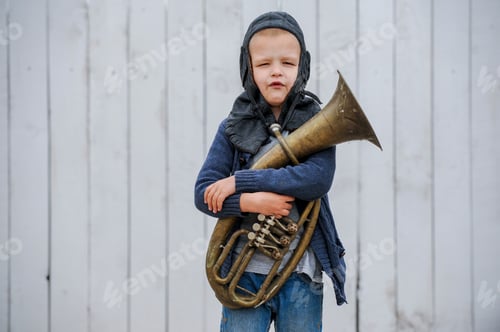 Preview: Funny Guy In Blue Sweater And Vintage Helmet Of Pilot Playing Large Copper Pipe
