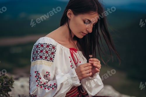 Preview: Attractive Woman In Traditional Romanian Costume On Mountain Green Blurred Background. Outdoor