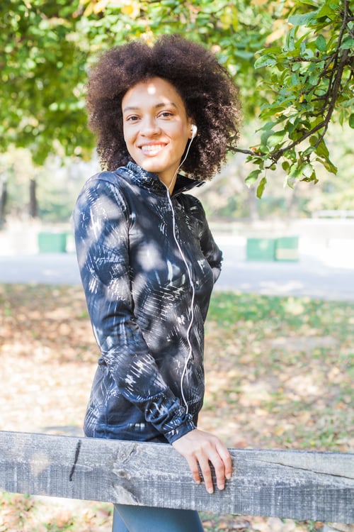 Preview: Attractive Sporty Woman Relax After Training Listening Music At Park, Leaning On Wooden Fence In