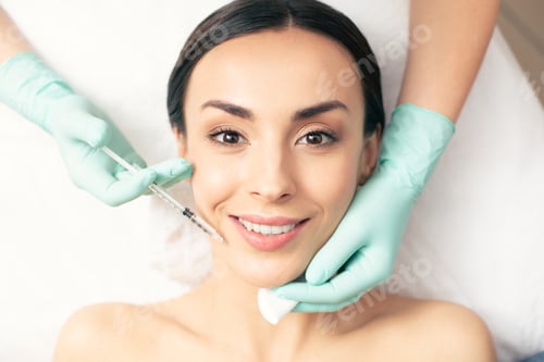 Preview: Cheerful Young Lady Feeling Good And Smiling While Getting The Injection Of Hyaluronic Acid