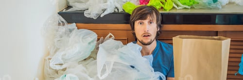Preview: Man Holding Paper Bag Amid A Pile Of Plastic Bags. Zero Waste Concept. The Concept Of World
