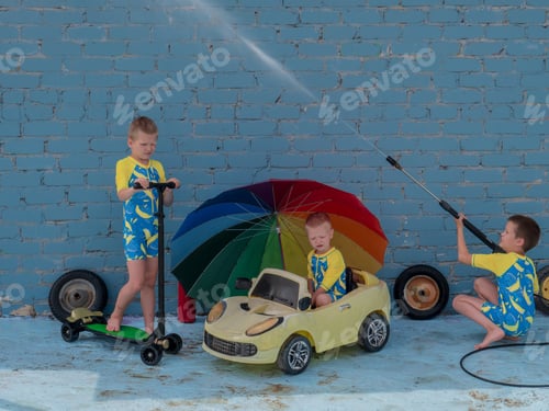 Preview: Funny Children In Boys' Bathing Suits Posing In Front Of Camera With High-Pressure Car Wash And Toy