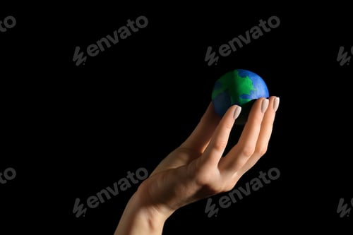 Preview: Female Hand With Model Of Earth On Dark Background