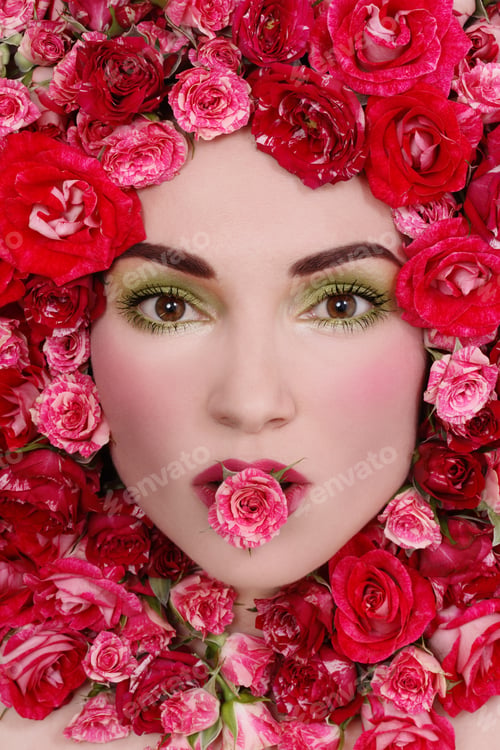 Preview: Close-Up Portrait Of Beautiful Young Fresh Girl In Pink Roses With Small Rose In Her Mouth