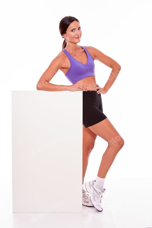 Preview: Healthy Smiling Brunette Woman Holding Blank Placard And Looking At Camera With One Hand On Her Hip