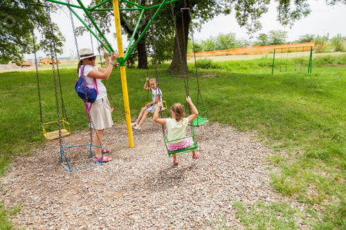 Preview: Mother And Daughters Have Fun In Summer Park At Carousel Swing