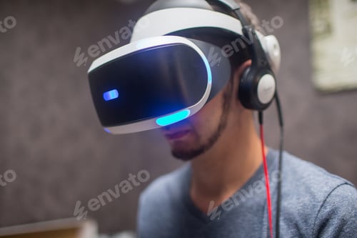 Preview: Young Man Wearing Vr Headset And Experiencing Virtual Reality And Plays Games With The Joystick At