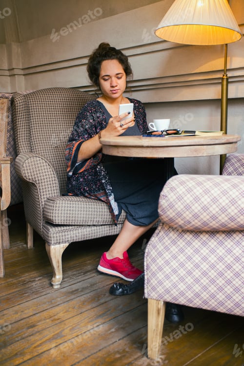 Preview: Breakfast - Girl Sitting With Smartphone And A Cup Of Coffee At The Cafe