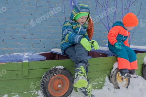 Preview: Happy Children In Winter In Warm Clothes Are Looking At Fire In Snow On The Village Yard. Children