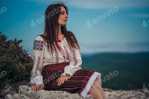 Preview: Attractive Woman In Traditional Romanian Costume On Mountain Green Blurred Background. Outdoor