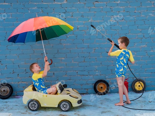 Preview: Funny Children In Boys' Bathing Suits Posing In Front Of Camera With High-Pressure Car Wash And Toy