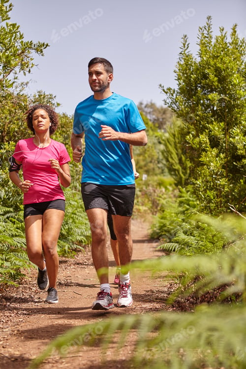 Preview: Three Young Joggers Out For A Run On A Gravel Path Surrounded By Bushes, Wearing Casual Running