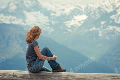 Preview: Girl Hiker Sitting And Looking At The Snowed Mountains