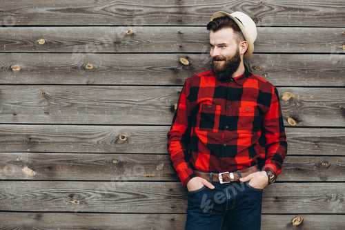 Preview: Portrait Of A Young Stylish Bearded Man Dressed Up In Jeans And A True Worker Black By Red Shirt On