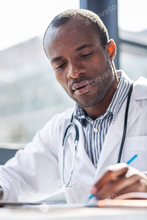 Preview: Medical Study. Handsome International Male Bowing Head While Looking At His Copybook