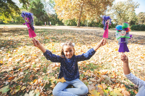 Preview: Happy Child Playing With Handmade Dolls At Autumn Day In The City Park.