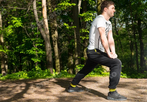 Preview: Sportsman Preparing For A Jog And Gets On One Knee In The Forest Alone