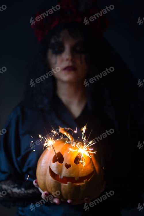 Preview: Jack-O-Lantern. Halloween - Girl In A Suit With A Pattern On Her Face And Pumpkin Lantern With Eyes