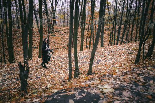 Preview: Charming Lady With Dreadlocks Wearing Black Mantle With Books Standing By The Old Tree In The