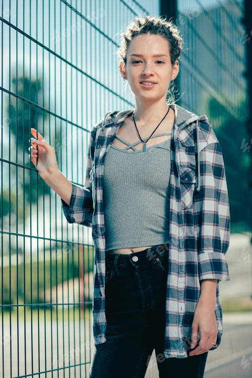 Preview: Young Woman in Plaid Shirt Leaning on Fence