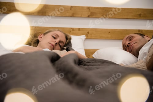 Preview: Couple Lying In A Bed With Their Eyes Closed As They Sleep