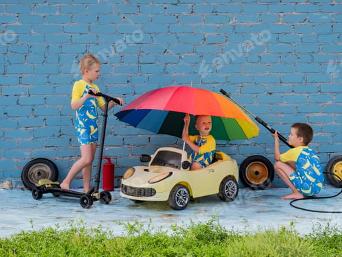 Preview: Funny Children In Boys' Bathing Suits Posing In Front Of Camera With High-Pressure Car Wash And Toy