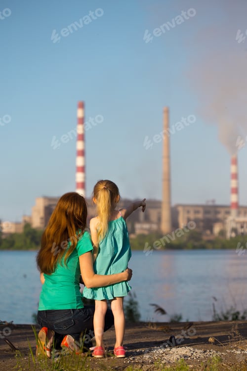 Preview: Care Future Concept. Young Mother With Her Kids Are Looking At The Chimney-Stalks Polluting An Air
