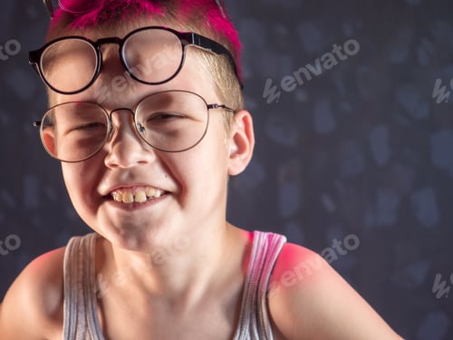 Preview: Photo Of Funny Boy, Blonde Kid With Lot Of Pairs Of Glasses On His Face. Child Is Happy At Home On