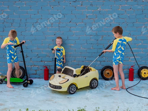 Preview: Funny Children In Boys' Bathing Suits Posing In Front Of Camera With High-Pressure Car Wash And Toy