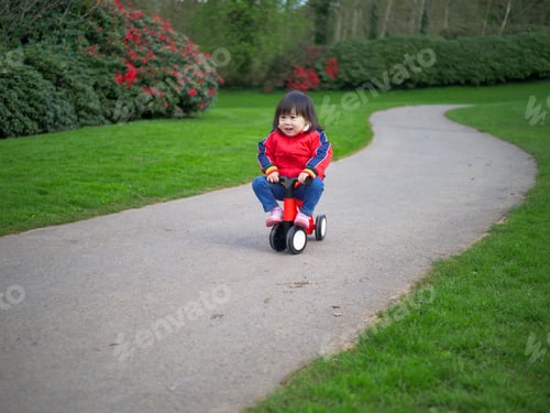 Preview: Baby Girl Play Bicycle At Outdoor Playground