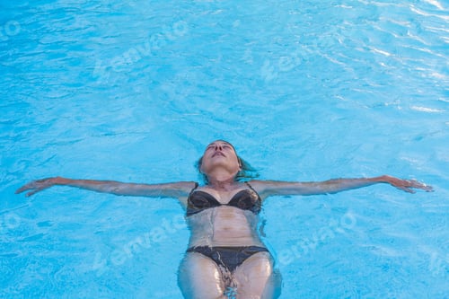 Preview: Top View Of A Woman In Bikini Floating On Her Back In A Swimming Pool
