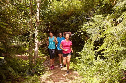 Preview: A Boy And Two Girls Running On A Jogging Trail Surrounded By Trees From Behind In The Late Morning