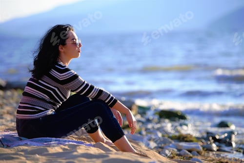 Preview: Beautiful Female Siting On The Beach Looking At The Sea Enjoying The Beautiful Fall Day.