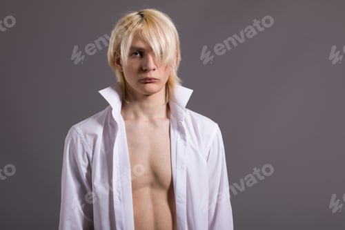 Preview: A Young Man With Stylish White Hair. Fashionable Guy In A White Shirt On A Gray Background.