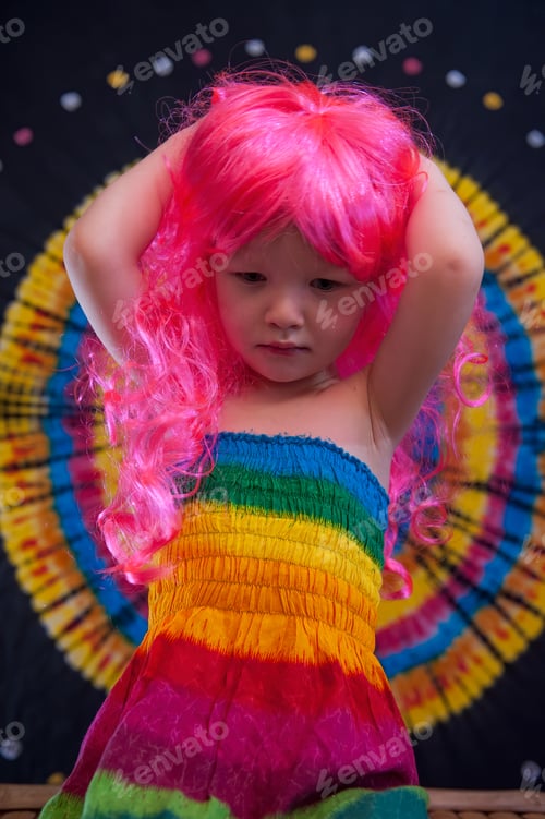 Preview: Happy Cute Caucasian Boy Changed Clothes At Carnival In Dress Of Girl Of Rainbow Color. Pink Doll