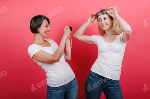 Preview: Friendship Concept. Happy Woman Take A Picture Her Friend Holding Photocamera